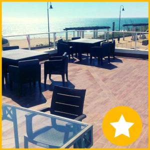 a patio with tables and chairs and the beach at Apartamentos Guga RTA A CA 00267 AT Edif Complejo 2 Llaves Playa in Conil de la Frontera