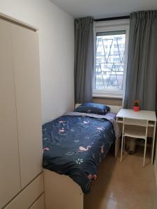 een kleine slaapkamer met een bed en een raam bij MirrorRoom PL CityCenter in Warschau