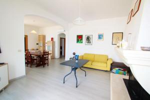 un soggiorno con divano giallo e tavolo di Beach house in Puglia a Torre Pali