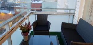 balcone con 2 sedie e tavolo con un vaso di Apartment in City - Antinkatu a Pori