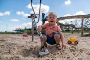 een kleine jongen die in het zand speelt op een speelplaats bij de Huttert Opkamer in Luttenberg