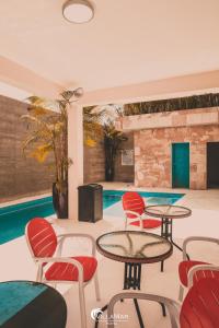a room with tables and chairs and a pool at Hotel Villamar in Veracruz