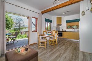a kitchen and living room with a table and chairs at Mountain View Cabana in Kommetjie