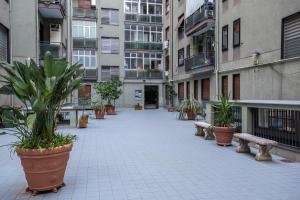 an empty courtyard with benches and potted plants at B&B Amalfi's Luxury Rooms in Salerno