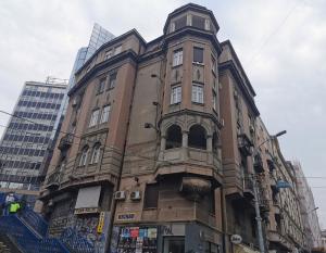 Un grand bâtiment avec une tour en haut dans l'établissement Max Central Apartment, à Belgrade