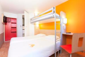 a bedroom with a bunk bed and a desk at Premiere Classe Caen Est - Mondeville in Mondeville