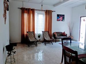 a living room with a glass table and chairs at Villa Two Residence in Mount Lavinia