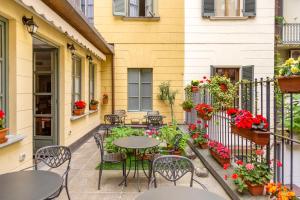 an outdoor patio with tables and chairs and flowers at Hotel Roma e Rocca Cavour in Turin