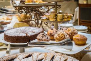 a display of cakes and pastries on a table at Hotel Roma e Rocca Cavour in Turin