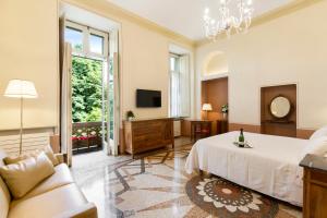 a bedroom with a bed and a couch and a tv at Hotel Roma e Rocca Cavour in Turin