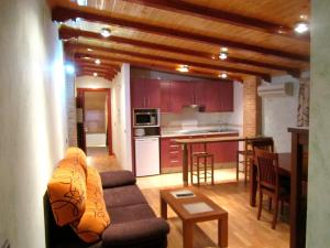Una sala de estar con un sofá y una cocina. en Apartamentos Almagro, en Almagro