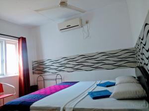 a bedroom with a bed with a wave mural on the wall at Villa Two Residence in Mount Lavinia