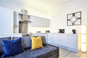 a living room with a couch and a kitchen at The Sunningdale - Your Apartment in Bristol