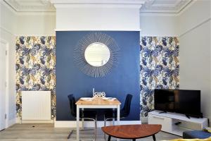 een woonkamer met een tafel en een spiegel bij The Sunningdale - Your Apartment in Bristol