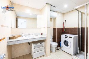 een badkamer met een wastafel en een wasmachine bij Vivienda Vacacional Malu in Costa Teguise