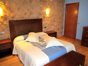 Un dormitorio con una cama grande con sábanas blancas. en Apartamentos Almagro, en Almagro