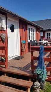 a deck with a red cabin with a white door at Lofotbo in Stamsund