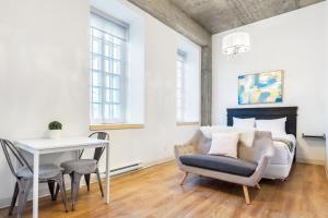 a living room with a table and a chair at Les Lofts de Buade - Par Les Lofts Vieux-Québec in Quebec City