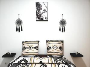 a bedroom with a bed with black and white pillows at Résidence Dalimier #hypercentre# in Corbeil-Essonnes