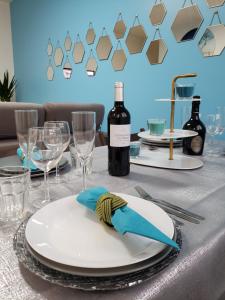 a table with a white plate with a bottle of wine at Résidence Dalimier #hypercentre# in Corbeil-Essonnes
