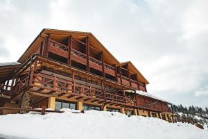 ein großes Blockhaus im Schnee in der Unterkunft Georgiy in Oryavchyk