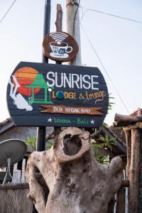 a sign for a sun rise dog and tennis at Sunrise Lodge & Lounge in Singaraja