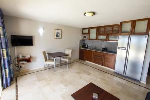 a kitchen with a table and a stainless steel refrigerator at Seaside Apartment Ibis in Kralendijk
