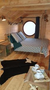 una habitación con una cama y una mesa en una cabaña en Kabanéo - gîte et sauna- Samois sur Seine - Forêt de Fontainebleau, en Samois-sur-Seine