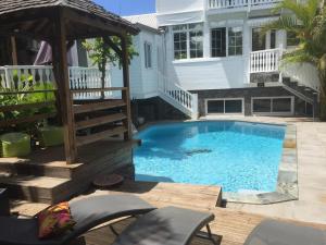 a swimming pool with a gazebo and a house at Loft Bellevue VILLA MORGANE, à 100m plage de Terre Sainte in Saint-Pierre