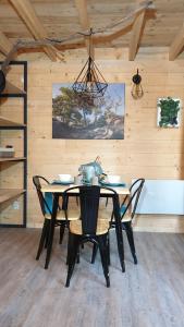 une salle à manger avec une table, des chaises et un lustre dans l'établissement Kabanéo - gîte et sauna- Samois sur Seine - Forêt de Fontainebleau, à Samois-sur-Seine