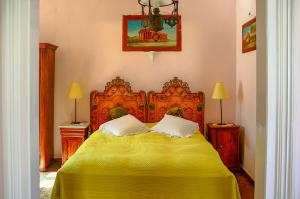 a bedroom with a yellow bed with two pillows at Villa Spetses in Spetses