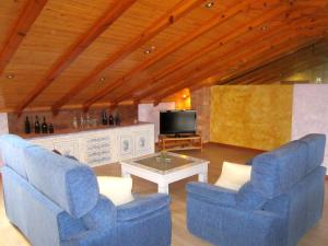 sala de estar con 2 sillas azules y TV en Apartamentos Almagro, en Almagro