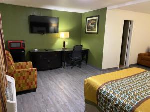 Una habitación de hotel con una cama, un escritorio y un televisor. en Palomino Motel, en Las Vegas