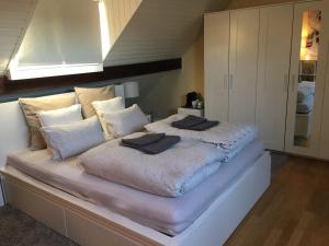 a bed with two pillows on it in a room at Cozy Attica - With Every Comfort - Berne in Liebefeld