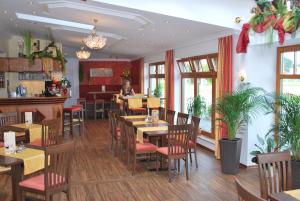a restaurant with tables and chairs and a woman in the background at Hotel Hutzenthaler in Bruckberg