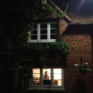 a woman looking out of a window of a brick building at The Hundred of Ashendon in Waddesdon