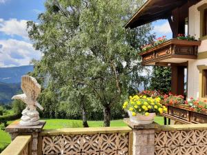 a balcony with a statue of a bird and flowers at Birkenhof in Millstatt