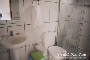 a bathroom with a toilet and a sink and a shower at POUSADA PORTAL DA LUZ in Entre Rios