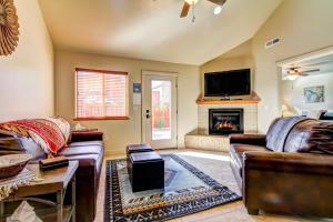 a living room with two leather couches and a fireplace at Desert Wind 17 in Spanish Valley