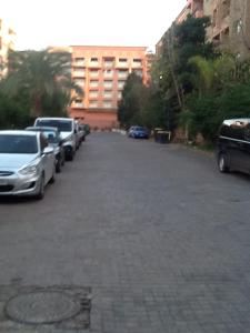 um parque de estacionamento com carros estacionados em frente a um edifício em Babylon Appartments em Marrakech