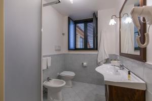 uma casa de banho com um lavatório, um WC e um espelho. em Flowers apartments & rooms em Meta