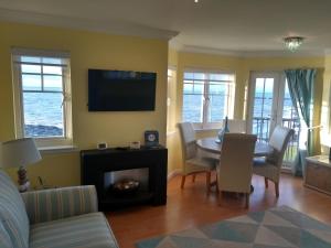 a living room with a table and chairs and a television at Wood Court, Troon in Troon