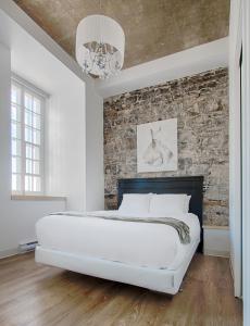 a bedroom with a brick wall and a large bed at Les Lofts de Buade - Par Les Lofts Vieux-Québec in Quebec City