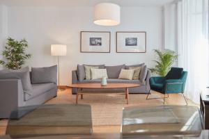 - un salon avec un canapé, une table et des chaises dans l'établissement Apartamentos La Bola Suite, à Ronda