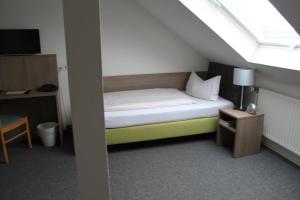 ein kleines Bett in einem Zimmer mit Fenster in der Unterkunft Hotel Sächsischer Hof in Chemnitz