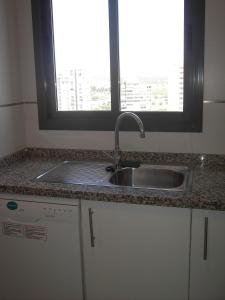 Una encimera de cocina con un fregadero y una ventana. en Apartamentos con terraza Torre D'Oboe by Renthas, en Benidorm
