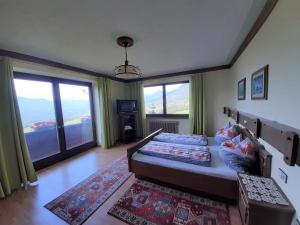 a bedroom with a large bed and large windows at Birkenhof in Millstatt