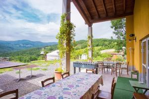 un patio con tavoli, sedie e vista di Società Agricola Cacigolara a Borgo Val di Taro