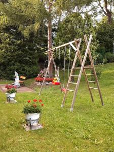 a swing set in a park with flowers in the grass at Birkenhof in Millstatt