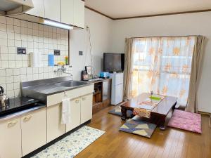 a kitchen with a sink and a table in it at kASUMI-an4 in Kumamoto